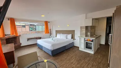 a hotel room with a bed and a kitchen at Hotel Cusco Museo in Cusco