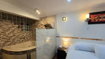 a bedroom with a tub and a bed and a bed and a bed at Hotel Cusco Museo in Cusco