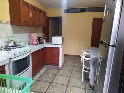 a kitchen with wooden cabinets and a stove top oven at A great experience in the South cone of Lima! in Lima