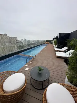 a balcony with chairs and a table and a swimming pool at Departamento amoblado de 1 dormitorio in Lima
