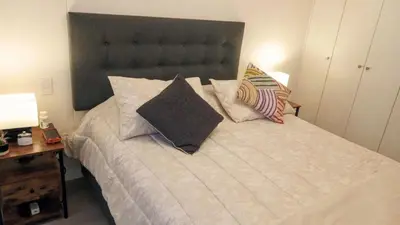 a bedroom with a large white bed with pillows at Departamento amoblado de 1 dormitorio in Lima