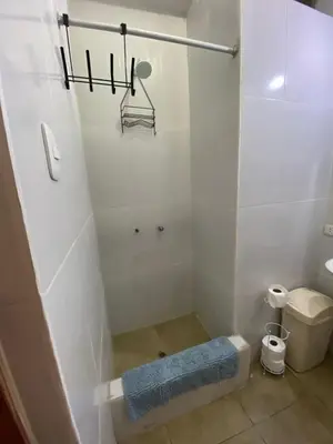a bathroom with a shower with a blue mat in it at Hostal Lobitos in Cerro Azul