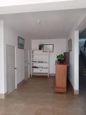 a hallway with a staircase and a dresser in a room at Hostal Lobitos in Cerro Azul