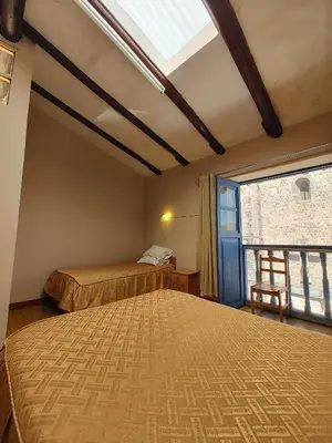 a bedroom with two beds and a window at Vista al Qoricancha - 2 cuadras de la Plaza in Cusco