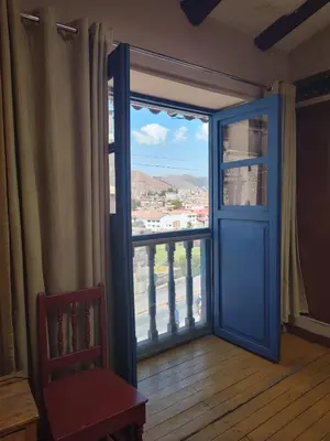 a room with a blue door and a window at Vista al Qoricancha - 2 cuadras de la Plaza in Cusco