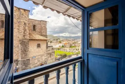a window with a blue door and a view of a city at Vista al Qoricancha - 2 cuadras de la Plaza in Cusco