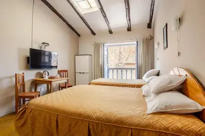 a bedroom with a bed and a desk and a television at Vista Qoricancha - 2 cuadras Plaza Principal in Cusco