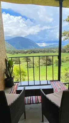 a balcony with chairs and a view of a mountain at Cabaña2 con hermosa vista al valle in Oxapampa