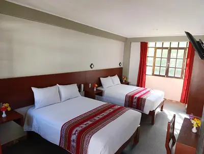 a hotel room with two beds and two windows at Samana House Ollantaytambo in Ollantaytambo