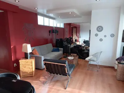 a living room with a white couch and red walls at Loft Minimalista de Lince in Lima