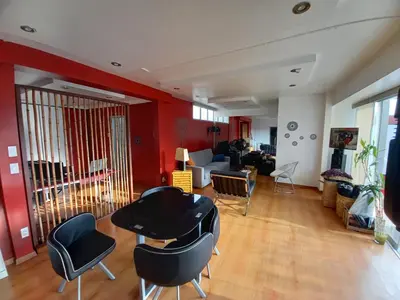 a living room with black chairs and red walls at Loft Minimalista de Lince in Lima