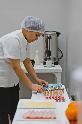 a woman standing in a kitchen preparing food at San Miguel Awanka Hotel in Lima