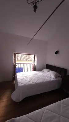 a bedroom with two beds and a window at Antuquita's House in Cusco