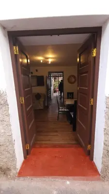 an open door into a hallway with a red rug at Antuquita's House in Cusco