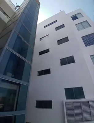 a white building with windows on the side of it at Duplex con piscina en Asia in Asia