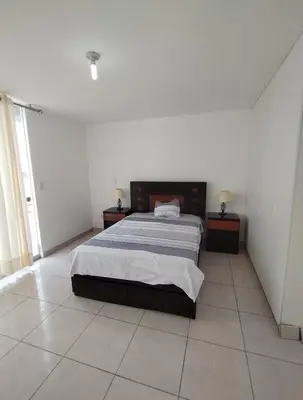 a bedroom with a large bed in a white room at Duplex con piscina en Asia in Asia