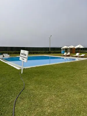 a sign in the grass next to a swimming pool at Mirador 101 in Asia