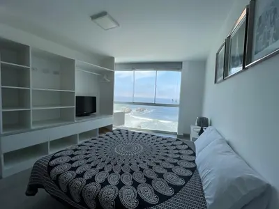 a bedroom with a bed and a view of the ocean at Casa de playa con vista al mar y piscina in Cerro Azul