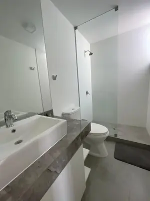 a white bathroom with a sink and a toilet at Casa de playa con vista al mar y piscina in Cerro Azul