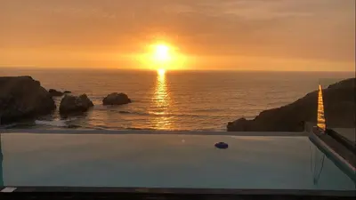 a bath tub with the sunset in the ocean at Casa de playa con vista al mar y piscina in Cerro Azul