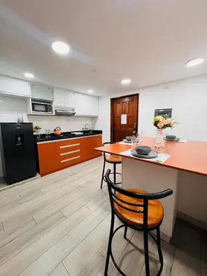 a kitchen with a table and two chairs and a counter at MONTERRICO POLO APARTS #8 - Dpto de 2 camas Frente Embajada de USA con AC in Lima