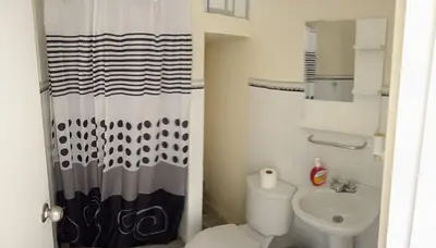 a bathroom with a toilet and a shower curtain at Sweet Rustic Home in Hacienda Santo Domingo