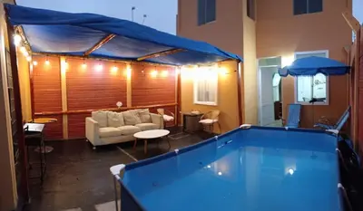 a large swimming pool in a living room with a tent at Sweet Rustic Home in Hacienda Santo Domingo