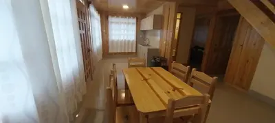 a wooden table and chairs in a room at Cabañas de casa hospedaje Mirador l in Oxapampa