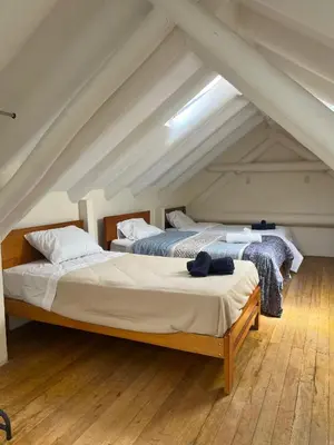 two beds in a room with an attic at Departamento 1 Waynapata Centro Histórico de Cusco in Cusco