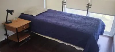 a bedroom with a purple bed and a nightstand and a window at Apartamento de Lujo in Lima
