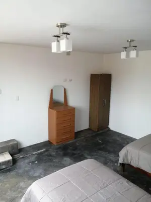 a bedroom with a bed and a wooden cabinet at Casa Extremadura in Lima