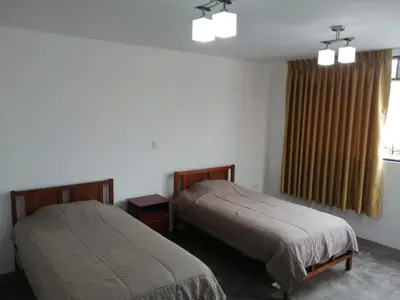 a bedroom with two beds and a window at Casa Extremadura in Lima