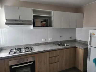 a kitchen with a sink and a stove top oven at Apartamento en Lima in Lima