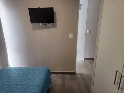 a room with a bed and a television on a wall at Apartamento en Lima in Lima