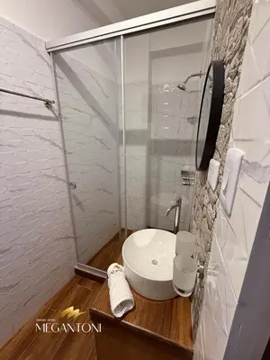 a bathroom with a white sink and a shower at Grand Hotel Megantoni in Quillabamba