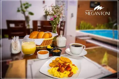 a table with a plate of breakfast food and a cup of coffee at Grand Hotel Megantoni in Quillabamba