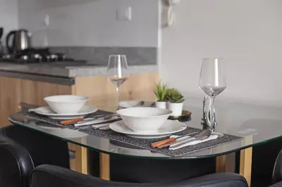 a table with plates and bowls and wine glasses at Luxury Barranco Pool Zoe in Lima