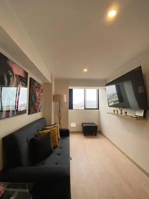 a living room with a couch and a flat screen tv at Luxury Barranco Pool Zoe in Lima