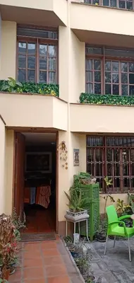 a building with green chairs and a patio at Habitación A1 Trabajar Kitchenette y baño privado in Lima