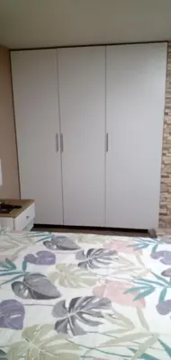 a room with white cabinets and a bed with flowers on it at Habitación A1 Trabajar Kitchenette y baño privado in Lima