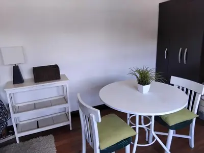a white table with two chairs and a table with a plant on it at Apartment in the historic center of Cusco in Cusco