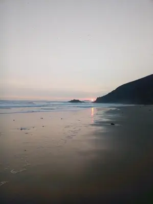 a beach with the sun setting in the distance at Relaxing Bungalow in Santa Rosa