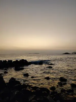 a beach with rocks in the water at sunset at Relaxing Bungalow in Santa Rosa