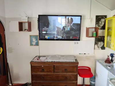 a room with a tv on a wall with a wooden dresser at Relaxing Bungalow in Santa Rosa