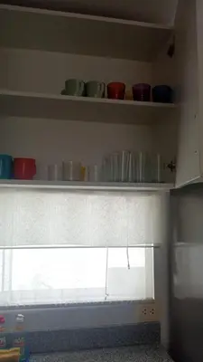a kitchen with shelves with bowls and cups on it at Departamento de playa in Asia