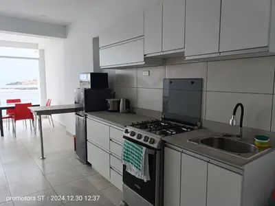 a kitchen with a stove and a sink and a table at Mirador sur in San Bartolo