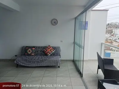 a couch in a living room with a clock on the wall at Mirador sur in San Bartolo