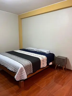 a bedroom with a bed and a table in it at 2da Habitacion a 1 cuadra de la Plaza in Oxapampa