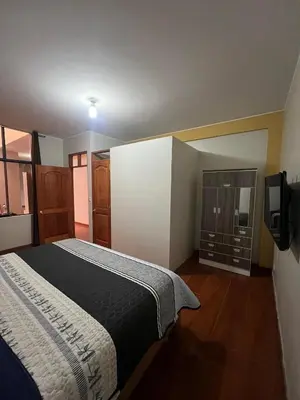 a bedroom with a bed and a tv on a wall at 2da Habitacion a 1 cuadra de la Plaza in Oxapampa