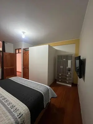 a bedroom with a bed and a tv on a wall at 2da Habitacion a 1 cuadra de la Plaza in Oxapampa